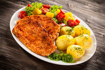 Fried pork chops, boiled potatoes and vegetable salad