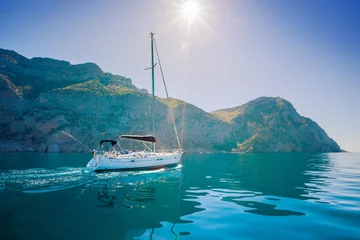 Zelfklevend Fotobehang Yacht sailing along the shore the sea in calm weather. © kuznetsov_konsta