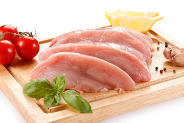 Raw chicken breasts on cutting board on white background
