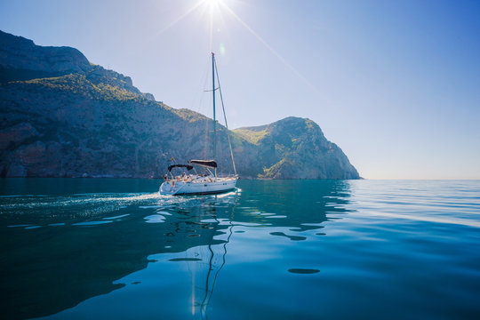 Yacht sailing along the shore the sea in calm weather.