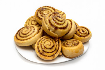 tasty cinnamon rolls on a dish isolated on white