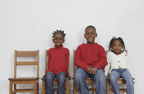 African siblings sitting in chairs