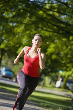 Hispanic woman running in park