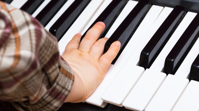 Close up of Keybord of synthetizer and child hands