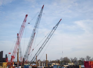 Fototapeta na wymiar Cranes and Industrial Work Area Against Blue Sky