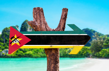 Mozambique Flag wooden sign with beach background