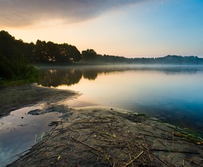 Beautiful sunrise over misty lake.