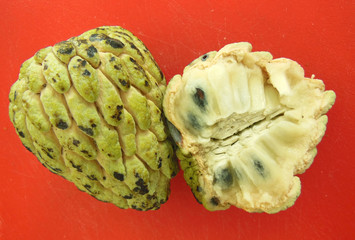 Cherimoya cut open on orange