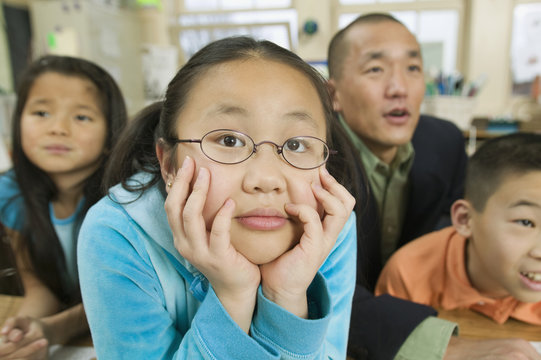 Asian children and father in classroom