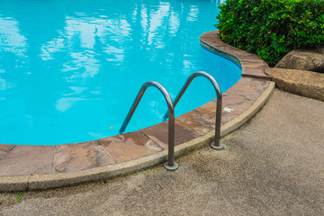 Grab bars ladder in blue swimming pool