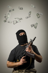 Man with gun and dollar banknotes.