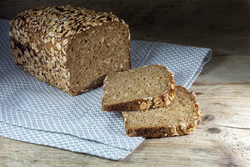 bread loaf with whole grain and seed on rustic wood, dark backgr