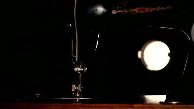 Antique working dark, brown and silver sewing machine on black