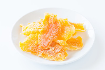 Piece of Dehydrated mango on white ceramic dish