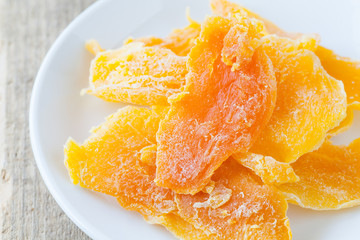 Piece of Dehydrated mango on white ceramic dish