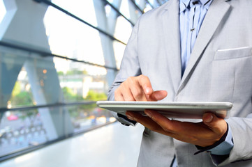 Handsome Young Business Man in Office Building using Digital Mob