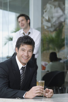 Hispanic businessman drinking cocktail