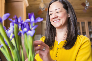 Mixed race woman arranging flowers