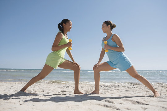 Hispanic woman exercising on beach
