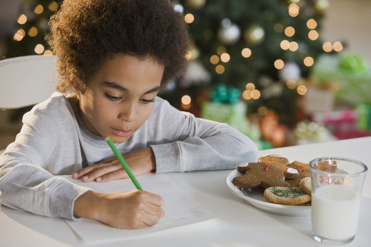 Mixed Race boy writing letter to Santa Claus