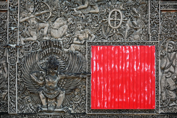 Balinese stone carving background with the red square shield