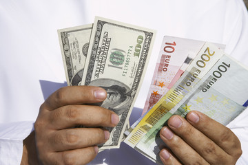 Close up of Arab man holding dollars and euros