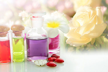 Obraz na płótnie Canvas Bottles of natural aroma oil on flowers background