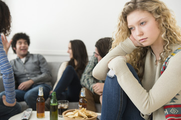Woman sitting apart from friends