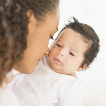 Hispanic mother nuzzling baby's cheek