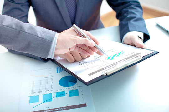 Two businessmen looking at report and having a discussion in off