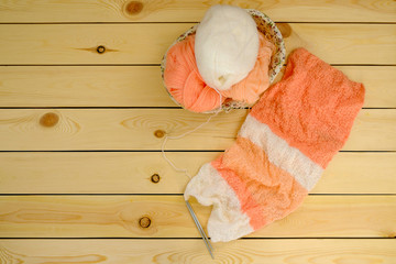 Knitted scarf with spokes on wooden background