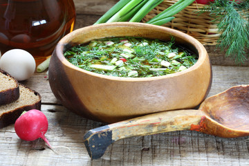 Okroshka with kvass in a wooden bowl and a wooden spoon