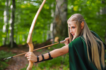 female elf with a bow in the forest