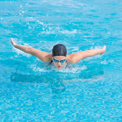 Young girl swimming butterfly stroke style