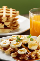 Waffles with bananas covered with maple syrup