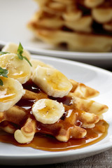 Waffles with bananas covered with maple syrup