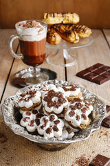 Tiny cookies in flower shape and cup of hot chocolate