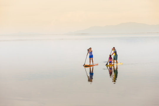 Family riding paddle boards
