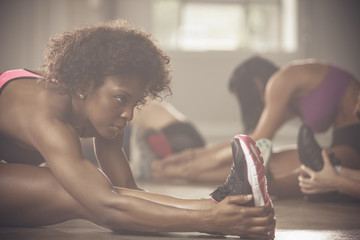 Black women stretching in gym