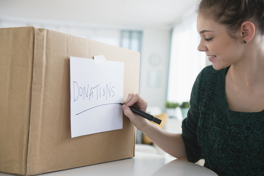 Hispanic girl marking ,'donations' box