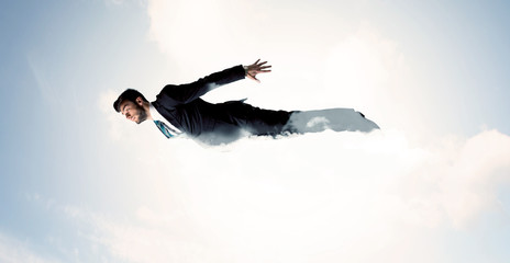 Business man flying like a superhero in clouds on the sky