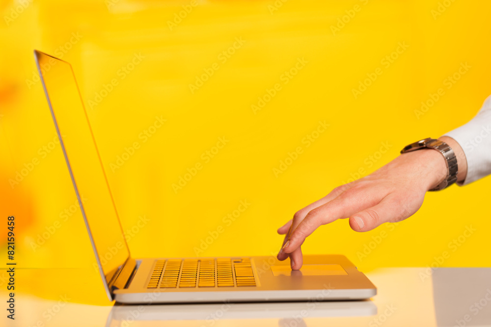 Wall mural Businessman pressing modern laptop computer on colorful backgrou