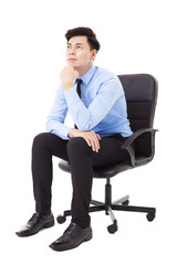 Young businessman sitting in a chair and thinking