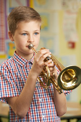 Boy Learning To Play Trumpet In School Music Lesson © highwaystarz