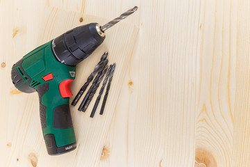 Electric drill and drill bits on a wooden background horizontal