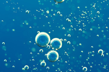 Macro Oxygen bubbles in water on blue background