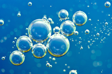 Macro Oxygen bubbles in water on blue background