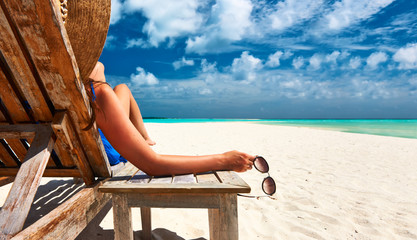 Žena na plaži drži sunčane naočale © haveseen