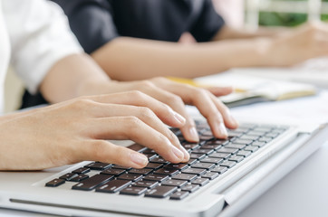 closeup of woman’s hands typing document in laptop