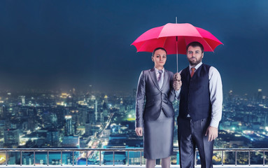 Business couple under umbrella